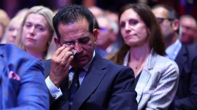 Dr Sanjoy Kumar pictured wiping his eyes during Kemi Badenoch's conference speech