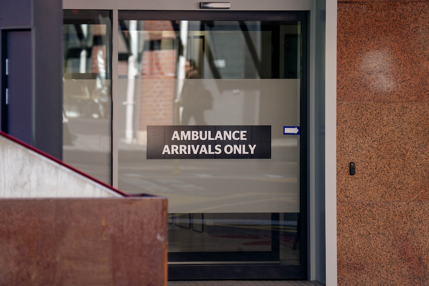 Signage on a glass door that says "AMBULANCE ARRIVALS ONLY".