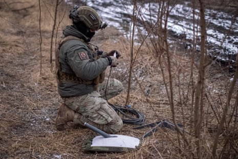 A Ukrainian serviceman of 47th brigade prepares a Starlink satellite internet systems at his positions at a front line.