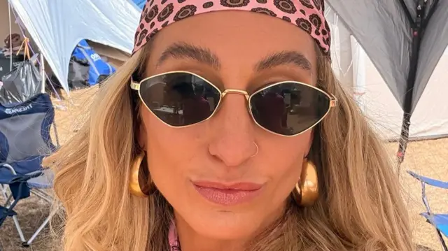 Zoe Scott wears sunglasses and a bandanna at a festival.