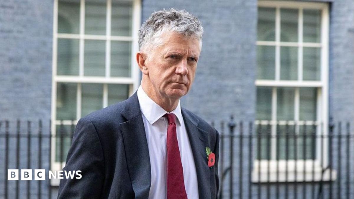 Jonathan Powell outside 10 Downing Street wearing a suit and tie.