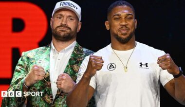 Anthony Joshua and Tyson Fury stand side-by-side and hold up their fists