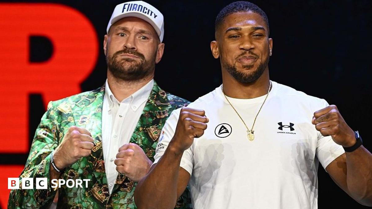 Anthony Joshua and Tyson Fury stand side-by-side and hold up their fists
