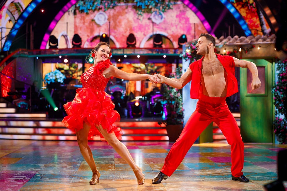 strictly come dancing lacey turner vito coppola two dancers in red costumes performing on a colorful stage