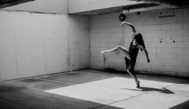 Monochrome image depicting a ballet dancer performing in a garage.