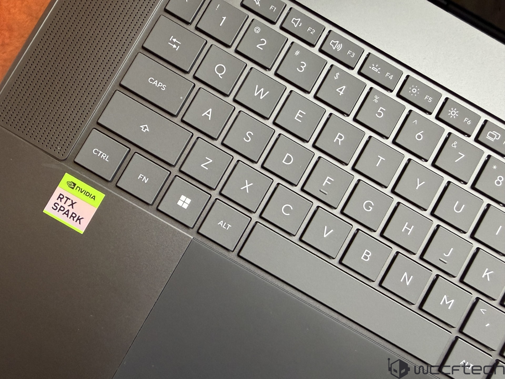 A laptop keyboard featuring an NVIDIA 'RTX SPARK' sticker beside the trackpad.