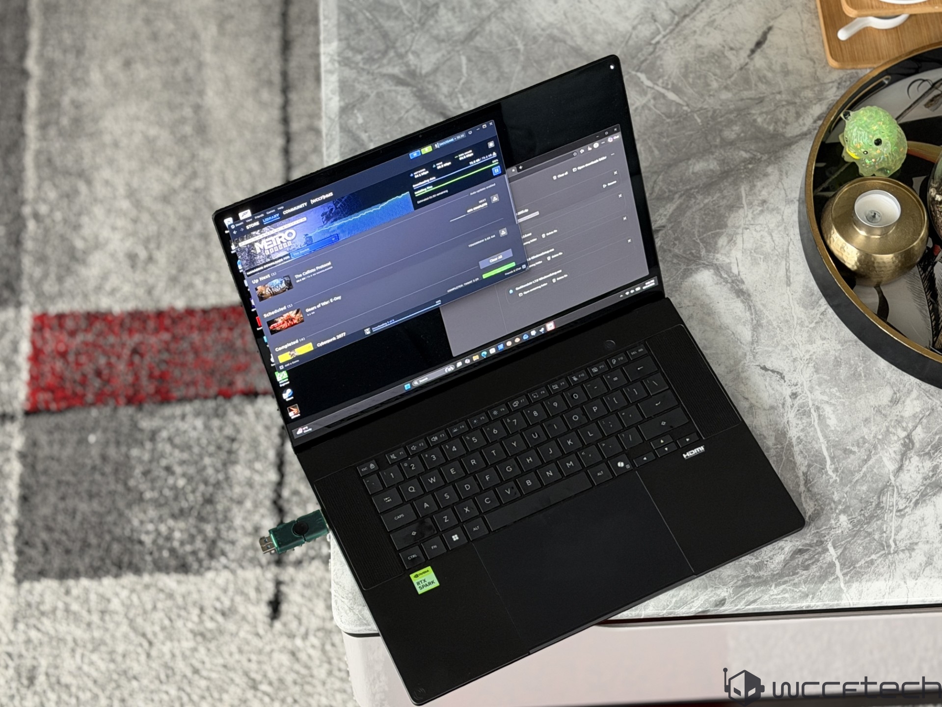 A black unbranded laptop displays the game 'METRO EXODUS' in a library interface.