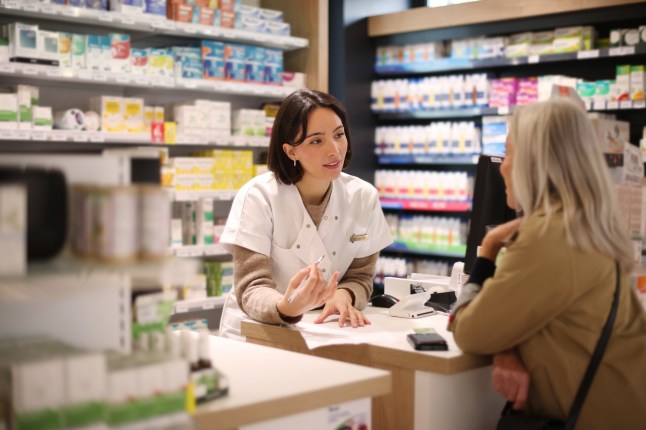 Pharmacist giving recommendations to a senior customer at a pharmacy counter