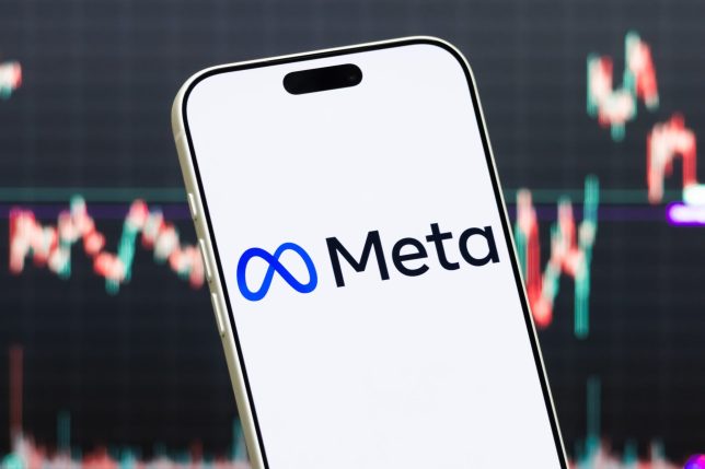 SHENZHEN, CHINA - JULY 23: In this photo illustration, a smartphone displays the logo of Meta Platforms, Inc. (NASDAQ: META), a global technology company and the parent company of Facebook, Instagram and WhatsApp, in front of a screen showing the company's latest stock market chart on July 23, 2026 in Shenzhen, Guangdong Province, China. (Photo illustration by Cheng Xin/Getty Images)