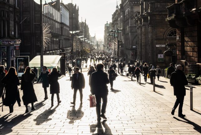 Winter sunshine during November creating a high contrast view of crowds on Buchanan Street in central Glasgow, Scotland.