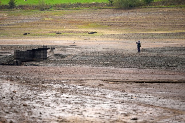 BAMFORD, UNITED KINGDOM - OCTOBER 19: People inspect the ruins of Derwent Village, flooded in the 1940s to provide drinking water for the East Midlands and Sheffield, become exposed due to the low water level at Ladybower Reservoir and drought conditions on October 19, 2026 in Bamford, United Kingdom. England is experiencing widespread drought conditions following a record-hot summer and the driest April-to-September period in over a century. Overall, roughly 82% of England remains in drought, 18 reservoir groups are less than half full, and temporary use restrictions remain active across large regions, requiring significant autumn and winter rainfall to replenish severely depleted groundwater and reservoir storage. (Photo by Christopher Furlong/Getty Images)