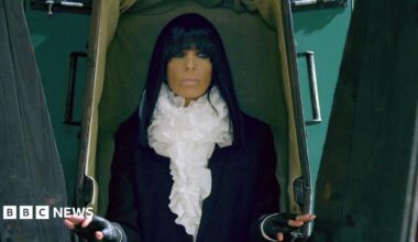 Claudia Winkleman emerging from a coffin