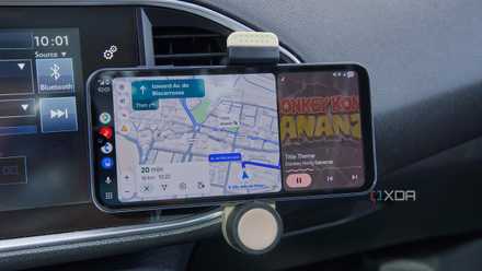 An Android phone displaying the Android Auto UI on a car's dashboard