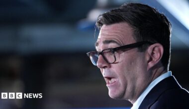 Close-up shot of Andy Burnham's face. The prime minister is wearing a dark suit jacket and light blue shirt.