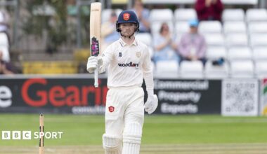 George Bell raising his bat after scoring a half-century for Essex