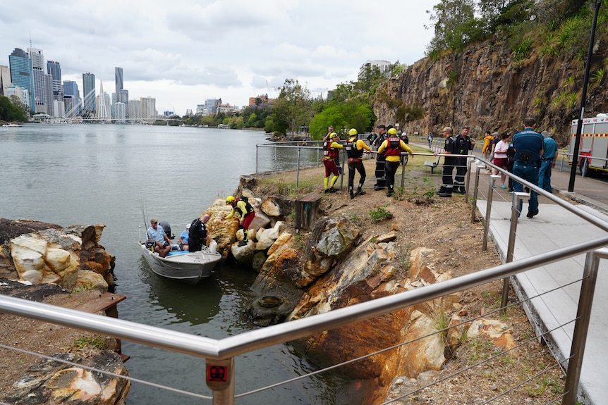 a tin boat on the brisbane river with emergency crew
