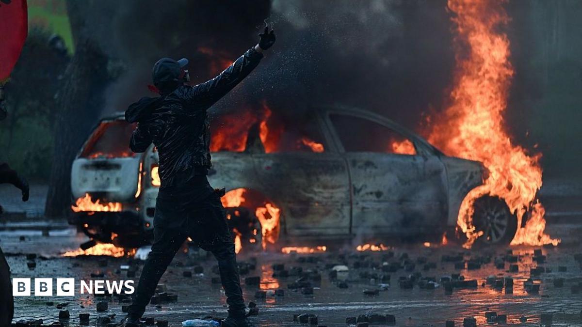 A protester cleaning tear gas from the eyes of another female demonstrator