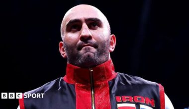Murat Gassiev waits in the ring before a fight dressed in red and black vest