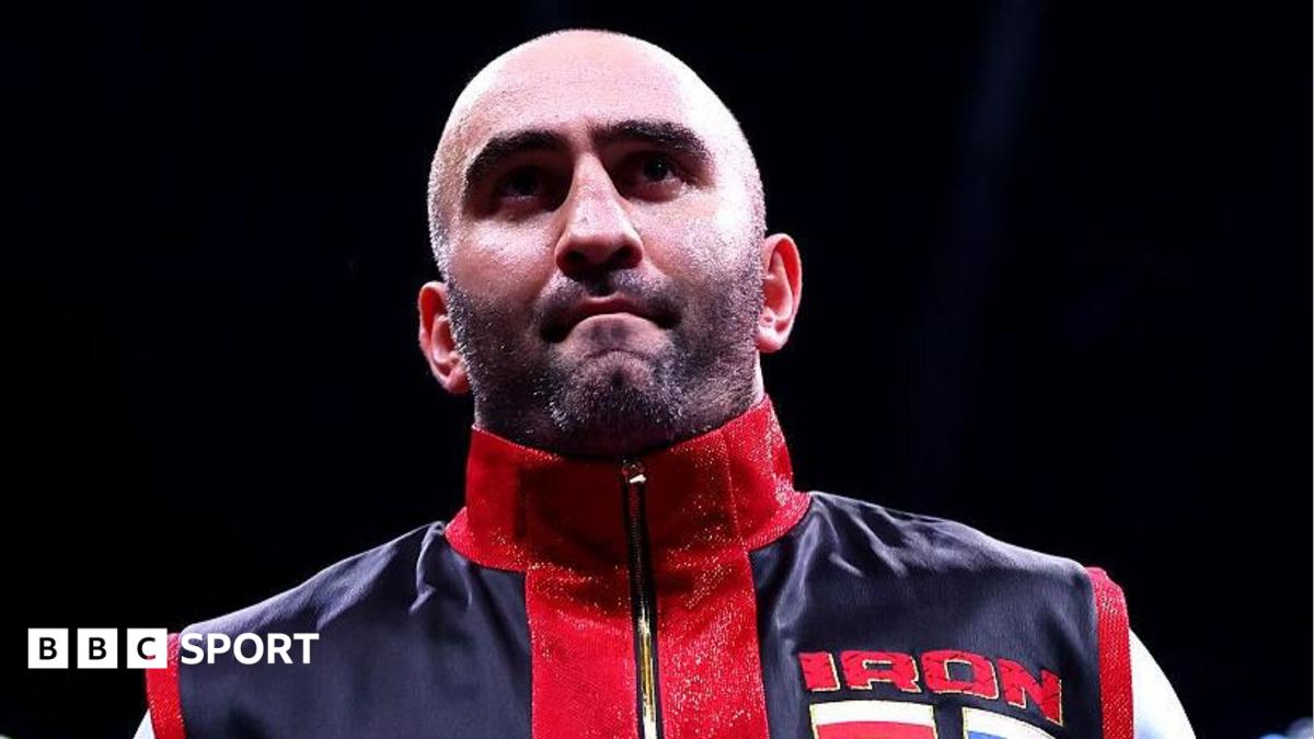 Murat Gassiev waits in the ring before a fight dressed in red and black vest