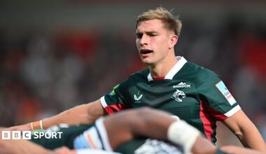 Jack van Poortvliet orchestrating his scrum who are seen just below him in soft focus, all wearing green Leicester tops