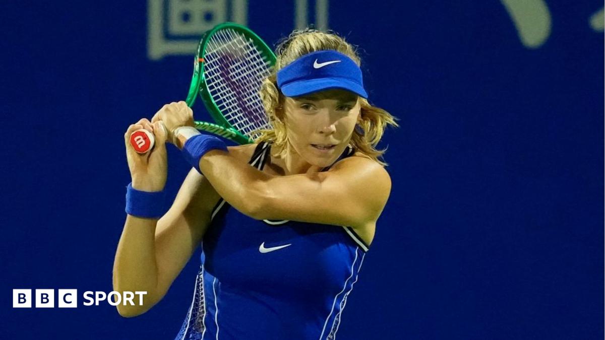 Katie Boulter in a blue outfit and cap, with her racket held near her head after playing a shot