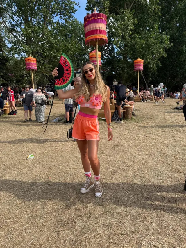 Zoe Scott wears sunglasses, a bandanna, a bikini top and shorts at a festival.