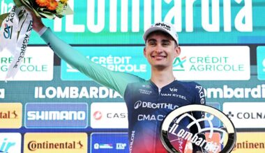 Seixas holding up the bouquet of flowers and trophy on the Lombardia podium