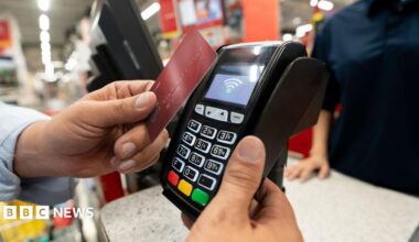 A person pays on a bank card at a shop card machine
