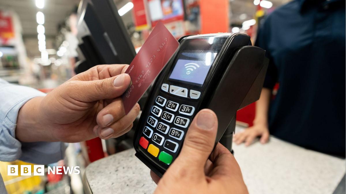 A person pays on a bank card at a shop card machine
