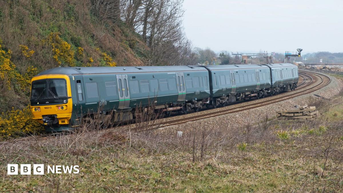 A Great Western Railway Class 165 Diesel Multiple Unit passenger train, with its distinctive green livery. It rounds a long, curved bend on the railway.