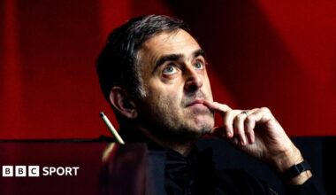 Ronnie O'Sullivan, looking upwards with his index finger touching the side of his mouth