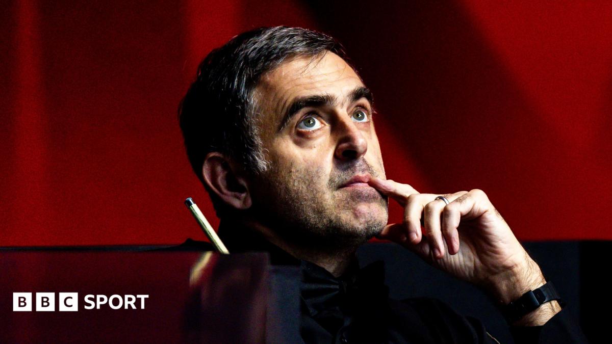Ronnie O'Sullivan, looking upwards with his index finger touching the side of his mouth