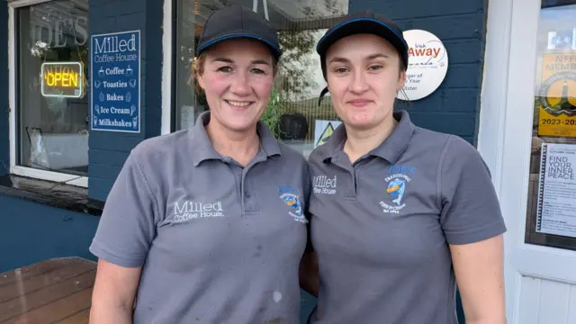 two women wearing grey polos and caps