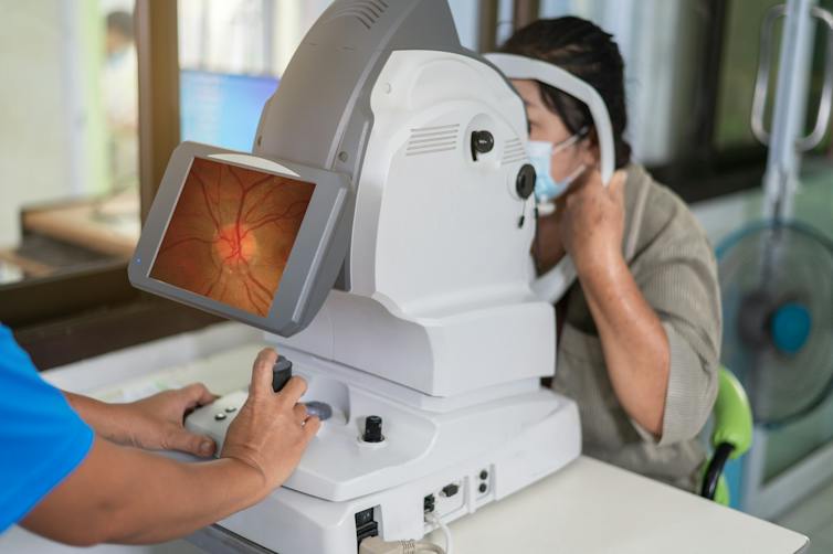 Ophthalmologist takes images of patient's retina using a refractometer eye test machine
