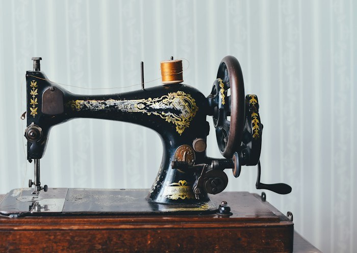 An antique black sewing machine with gold details, a vintage treasure among dumpster finds.