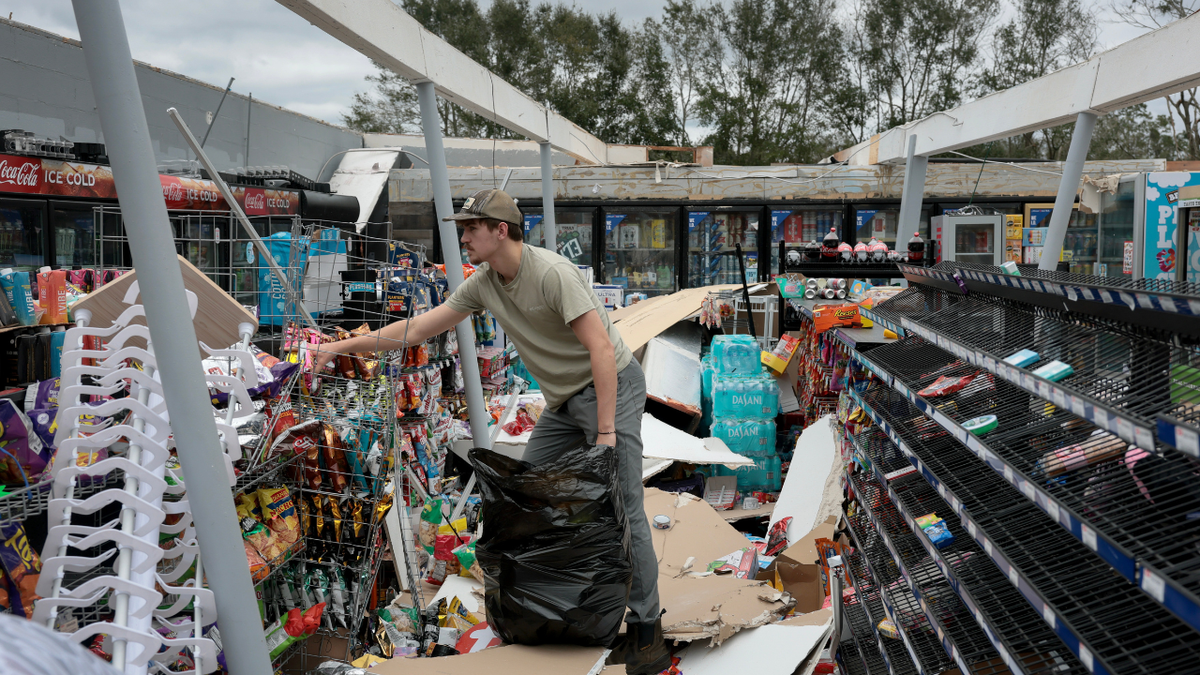 A man cleans up a store after Hurricane Isaias passed through the area on October 10, 2026, in Milton, Florida.