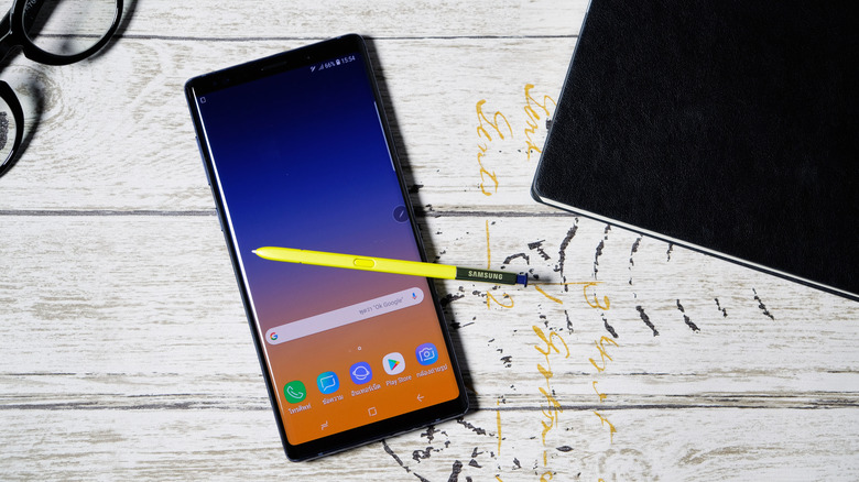 Top-down view of Samsung Galaxy Note 9 with stylus resting atop a table.