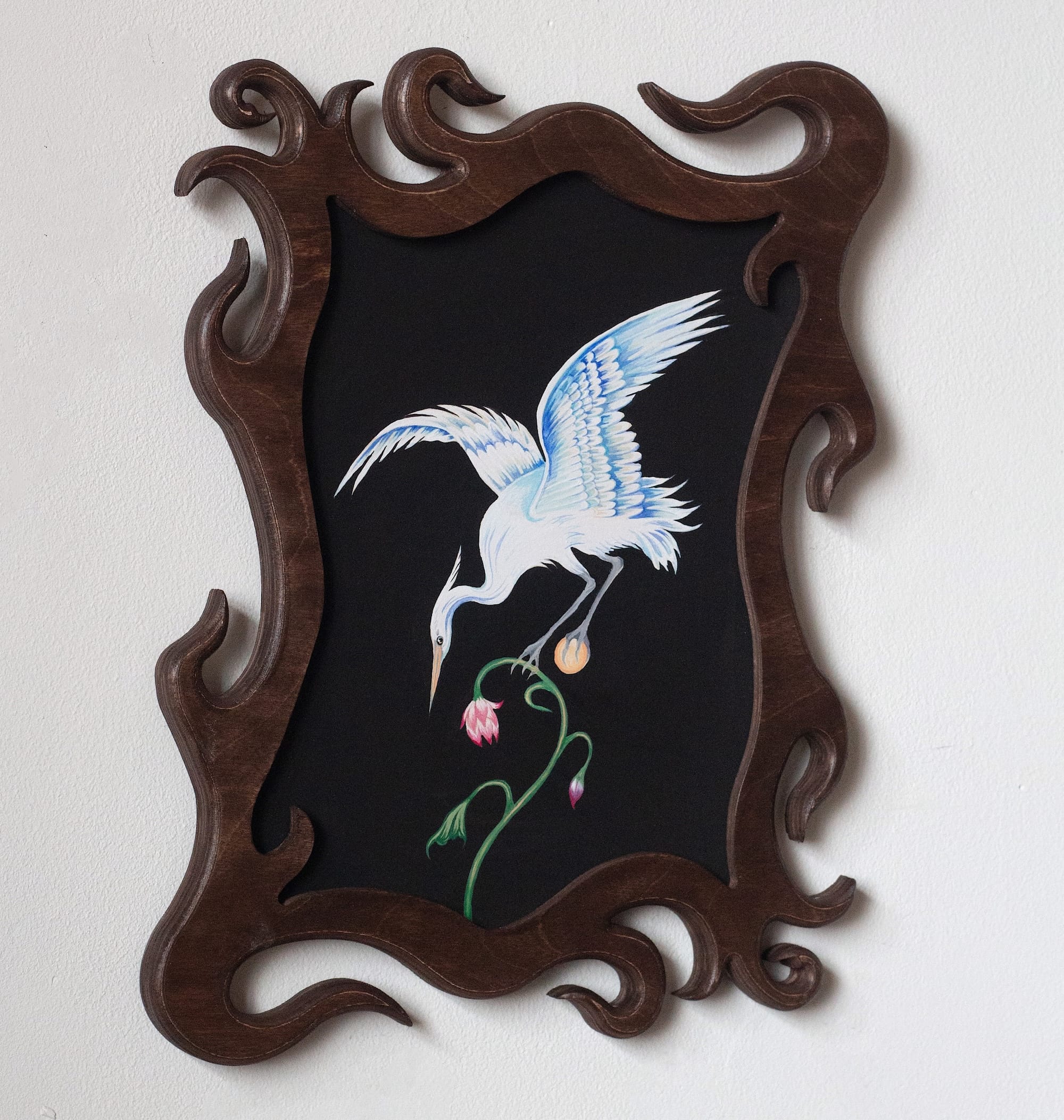a painting of a crane on a black background with a swirling, carved wooden frame