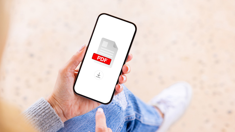 person looking at phone with large PDF logo and download button on screen