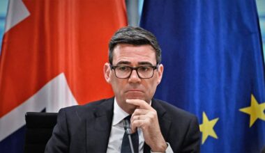 Andy Burnham in front of a British and EU flag