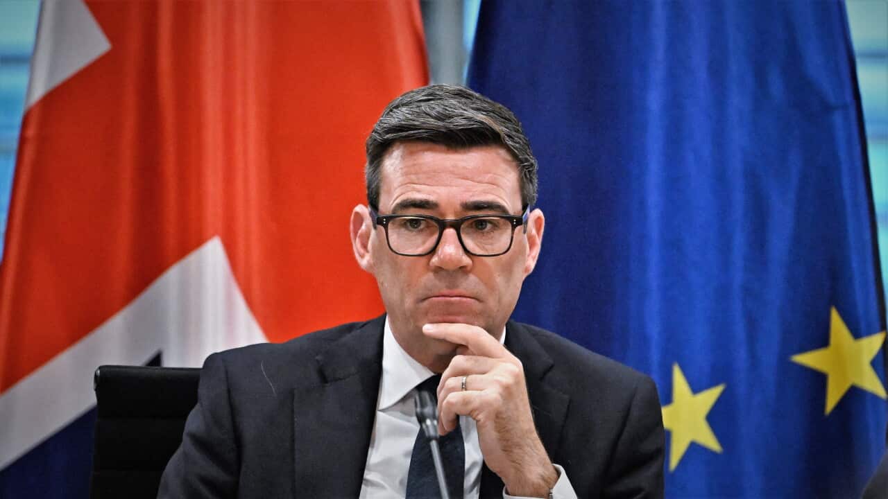 Andy Burnham in front of a British and EU flag