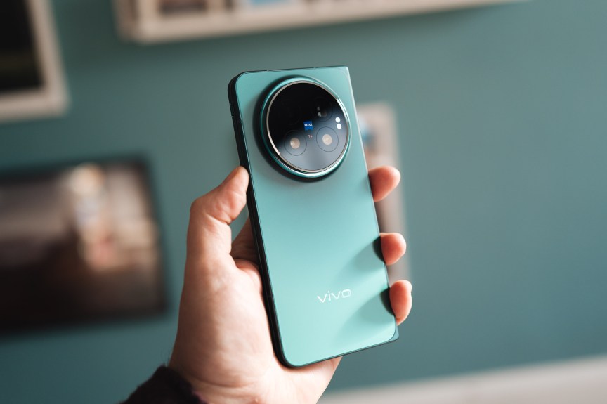 A hand holds up the Vivo X Fold 6, showing off the beautiful blue back.