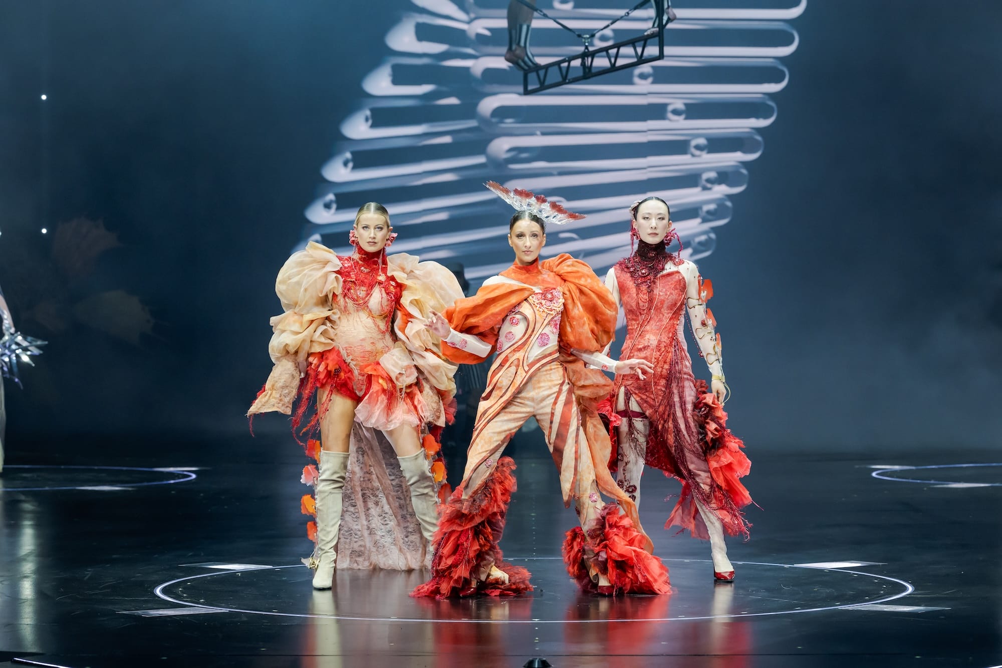 three elaborate outfits worn by dancers on a stage