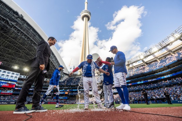 Alejandro Kirk of the Toronto Blue Jays gets water dumped on him by teammate Vladimir Guerrero Jr. #27 during his post game interview after their team defeated the Los Angeles Angels in their MLB game at the Rogers Centre on July 29, 2023 in Toronto, Ontario, Canada. (Photo by Mark Blinch/Getty Images)