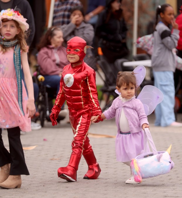 Lucca Montiel, 6, Alma, 1, of Castro Valley, take part in a costume contest parade during the Halloween Día de los Muertos Family Fun Fest at Jack London Square in Oakland, Calif., on Sunday, Oct. 26, 2025. (Jane Tyska/Bay Area News Group)