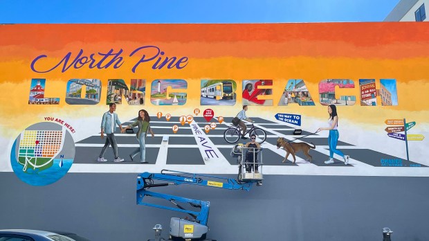 Artist Robert Lebsack painting his North Pine mural, located at...