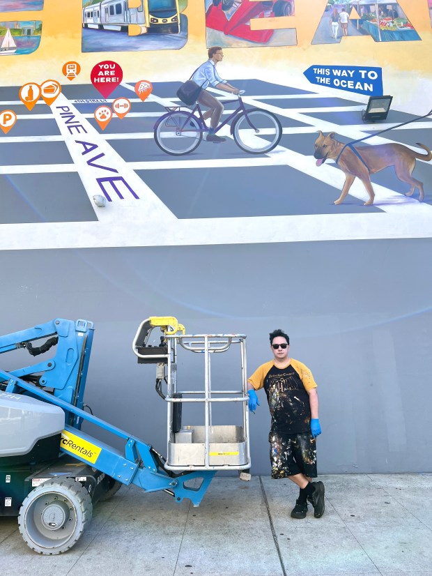 Artist Robert Lebsack painting his North Pine mural, located at...