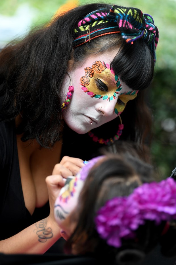 Bianca does face painting at the Día de los Muertos...