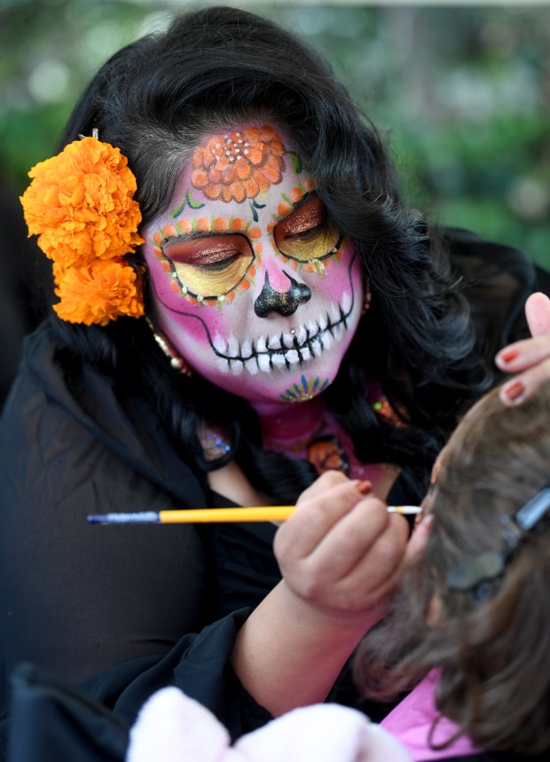 Elizabeth Calaveras Zapotecas does face painting at the Día de...