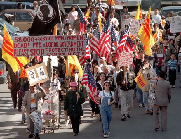 Holding flags and signs and shouting "down with communism, down with Ho CHi Mihn" more than 500 anti-communist demonstrators march outside the video store owned by Truong Van Tran, snaking their way around the strip mall in a line that stretched a city block. The store owner had been at the center of protests since he hung a picture of Hi Chi Mihn and the communist flag in his store, Hitek Video in Little Saigon. The protest lasted several hours as marchers circled the block again and again. (Photo by Chas Metivier/The Orange County Register)